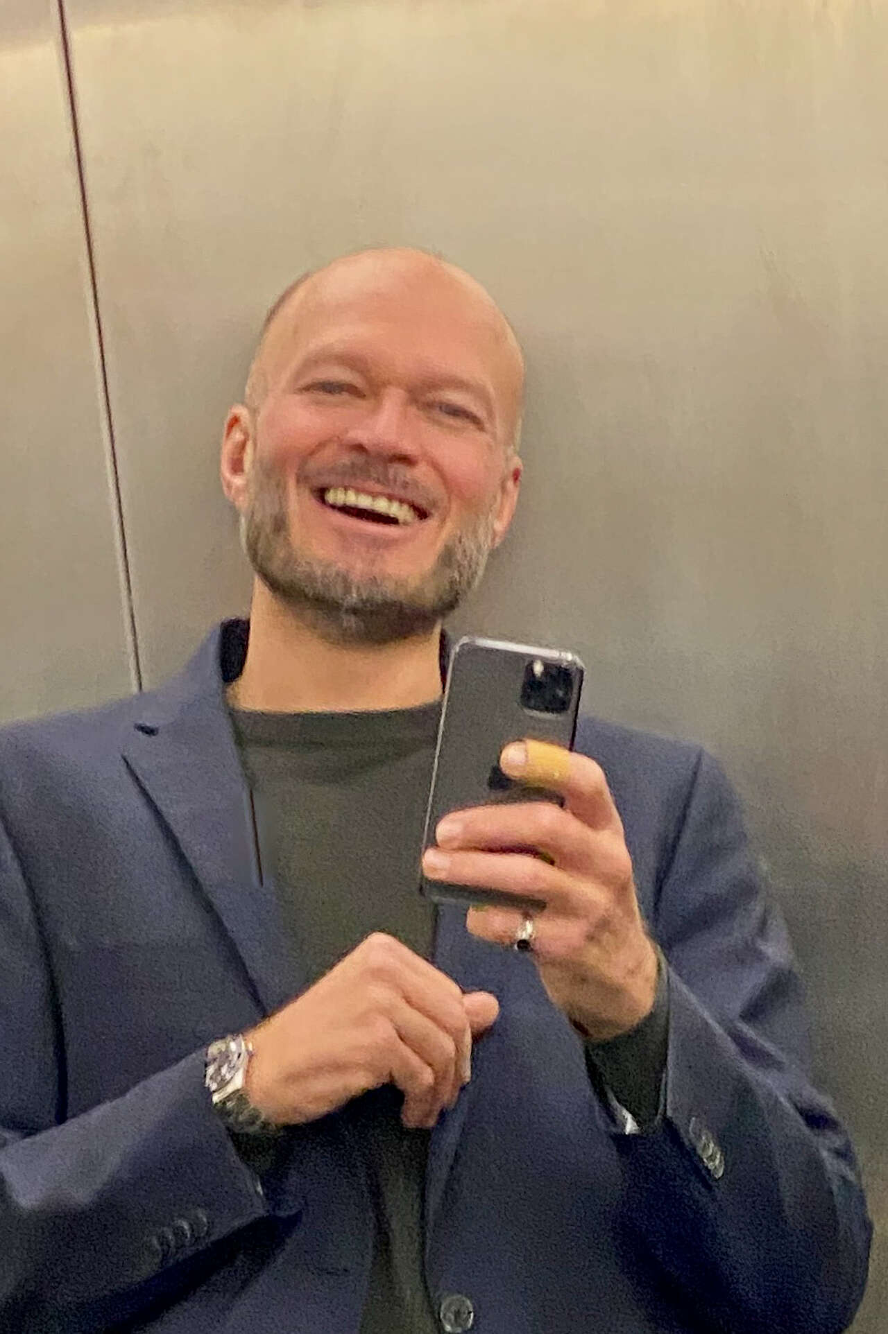 Tomas Renner mit Iphone im Spiegel eines Aufzugs